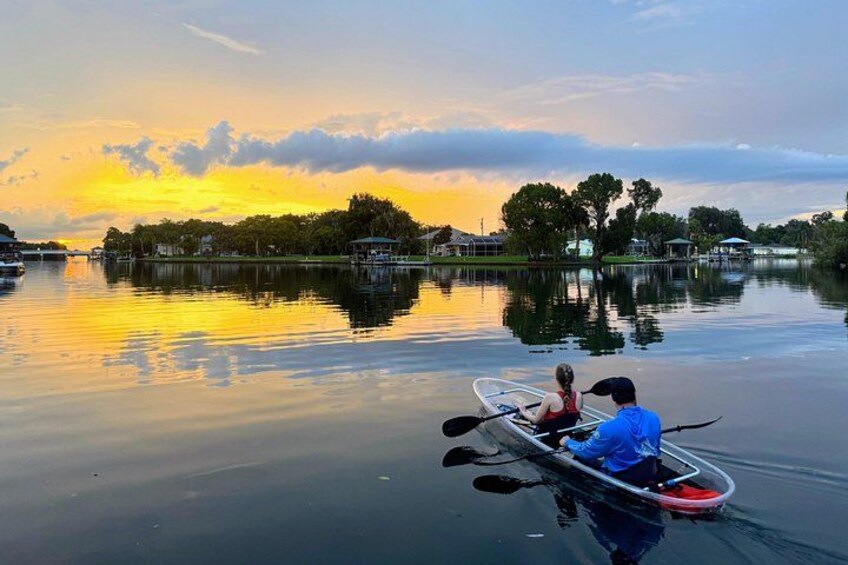 A calm lake at sunset with a kayak and a person in it. 5