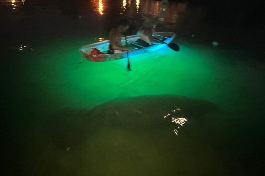 A person paddling a kayak on a body of water at night. 3