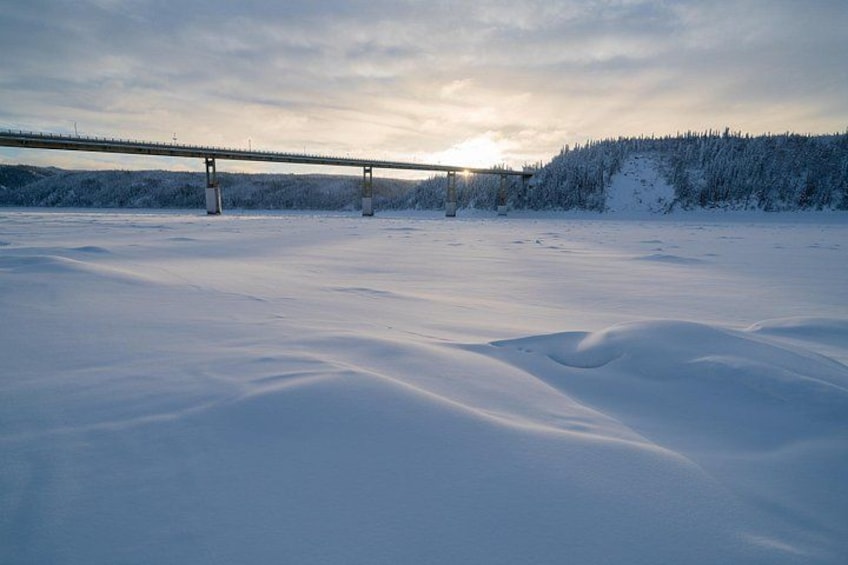 Paisaje nevado con un puente y un bosque al fondo. 2