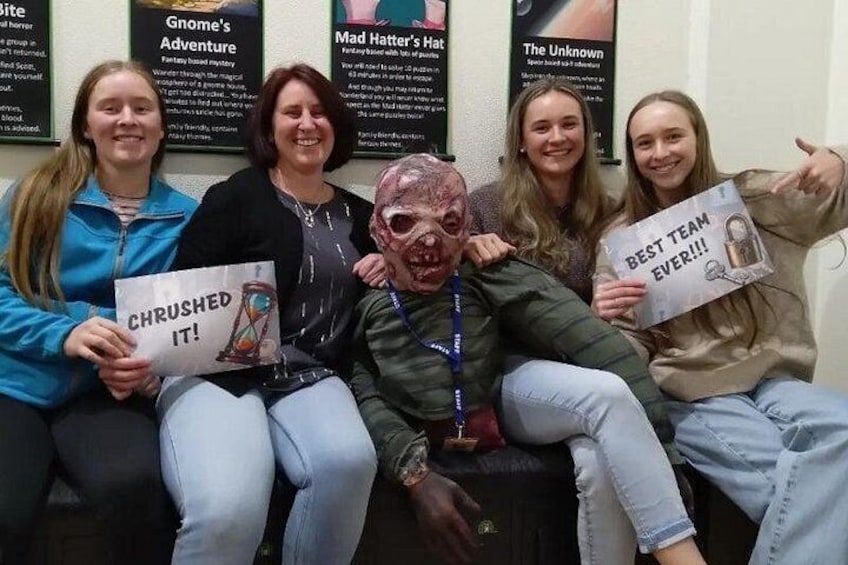 A group of people sitting on a bench, holding signs with book titles. 4