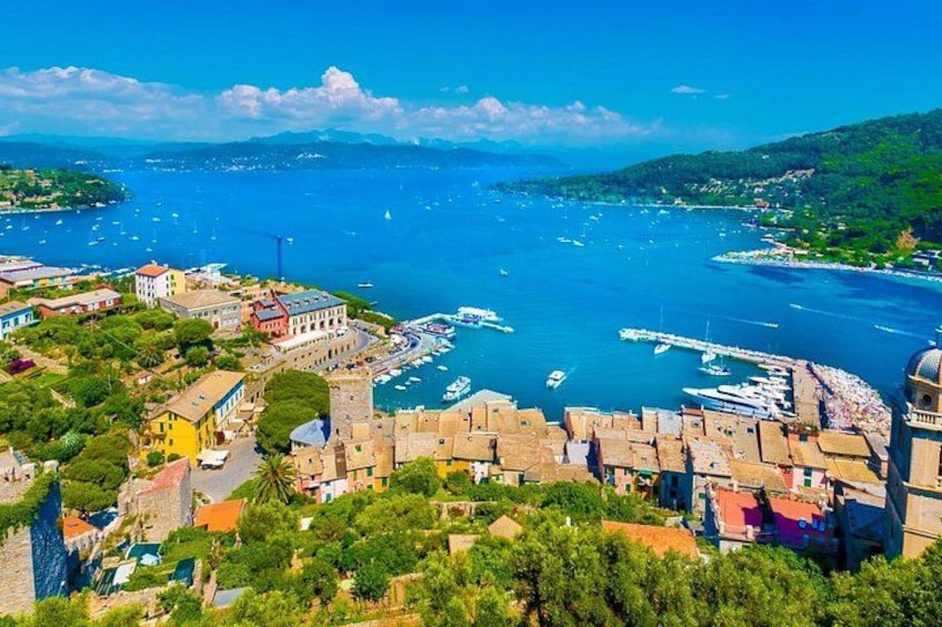 A coastal town with a marina, historic buildings, and a mountainous backdrop. 4