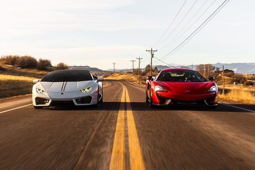 Two sports cars on a rural road with a clear sky. 4