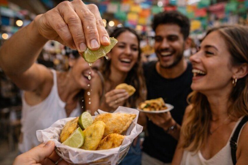 A person holding a basket of fried food with lime wedges. 5