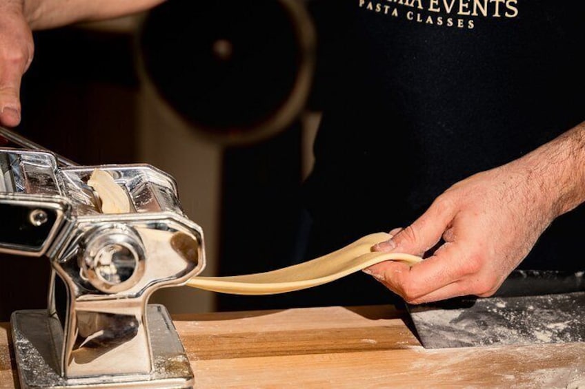 Une personne utilise une machine à pâtes pour étaler la pâte. 4
