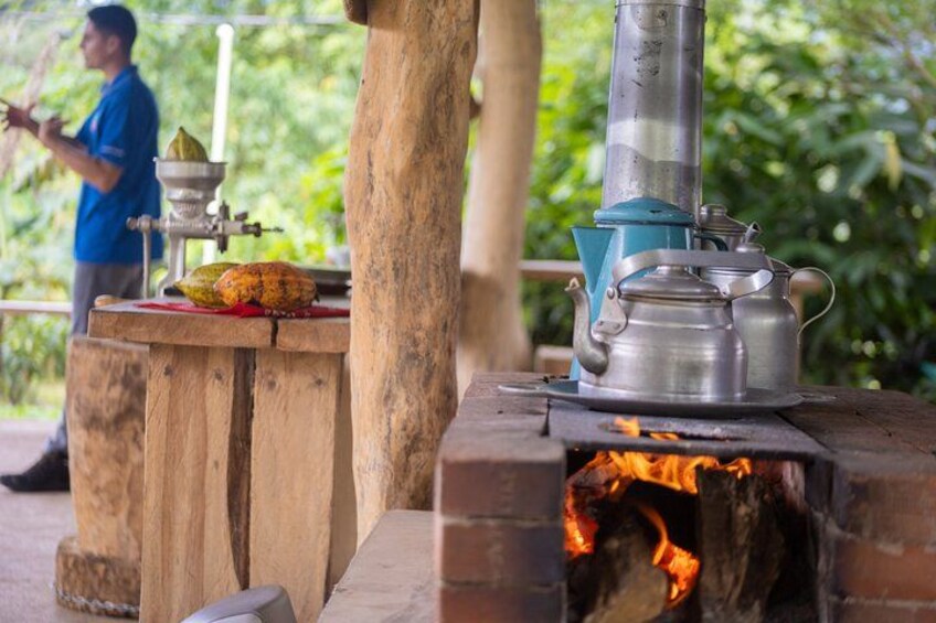 A traditional cooking stove with a pot and a person in the background. 2
