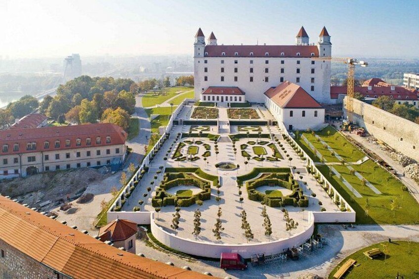 Eine große Burg mit einem gepflegten Garten und einem Burggraben. 1
