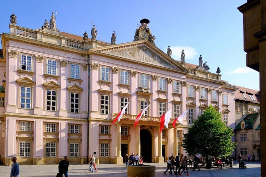 Ein historisches Gebäude mit klassischer Architektur, Flaggen und einem zentralen Innenhof. 2