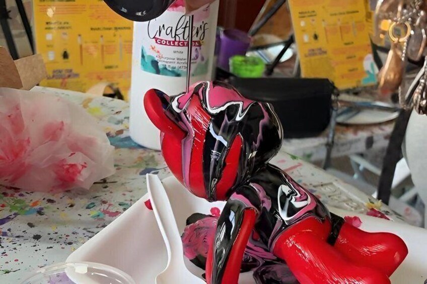 A red and black helmet on a table with a white container and a bottle labeled 'Crafts.' 1
