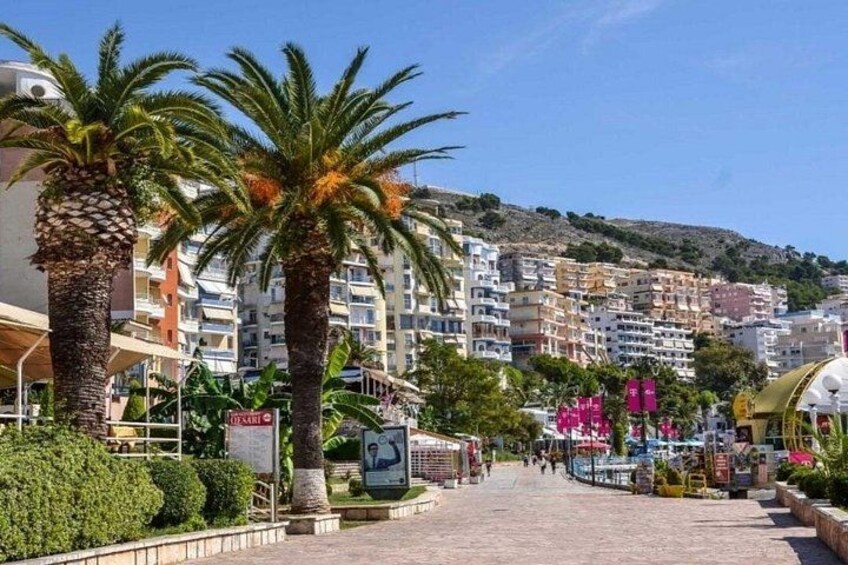 A coastal town with palm trees, multi-story buildings, and a clear sky. 3