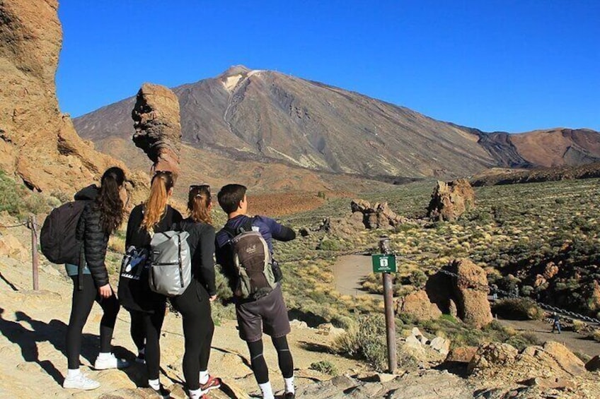 Een groep wandelaars op een pad, met een berg op de achtergrond. 5