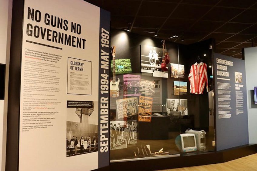 A museum exhibit with historical documents, photographs, and artifacts related to the No Guns No Government movement from 1994-1997. 1