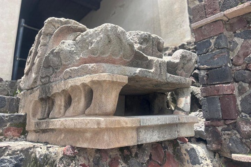 En stenskulptur med et løvehoved og en sokkel med udskårne figurer. 3
