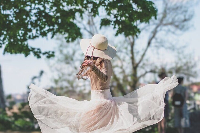 A person in a white dress and hat, spinning with arms outstretched. 1