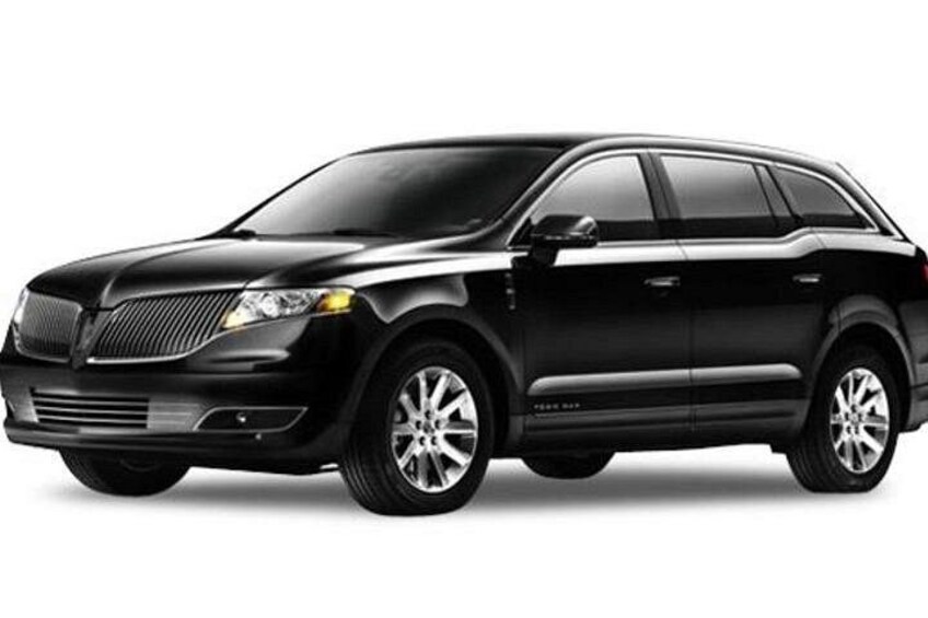 A black SUV with a chrome grille, alloy wheels, and a visible side step. 4