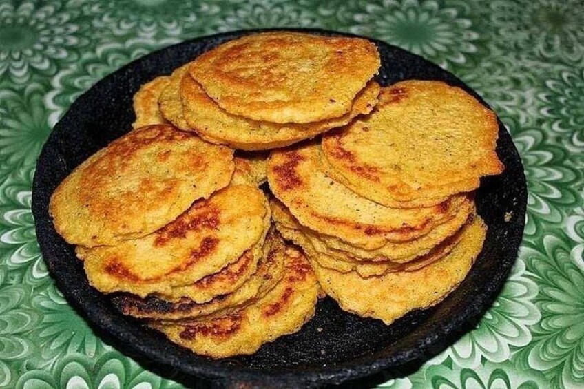 Une pile de crêpes dorées et légèrement brunes, disposées sur une assiette noire. 4