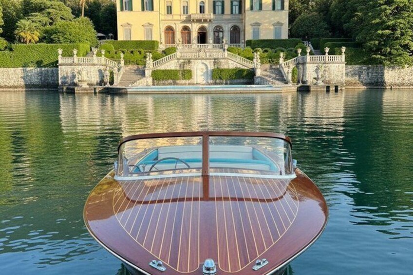 A wooden boat on calm water with a grand building in the background. 3