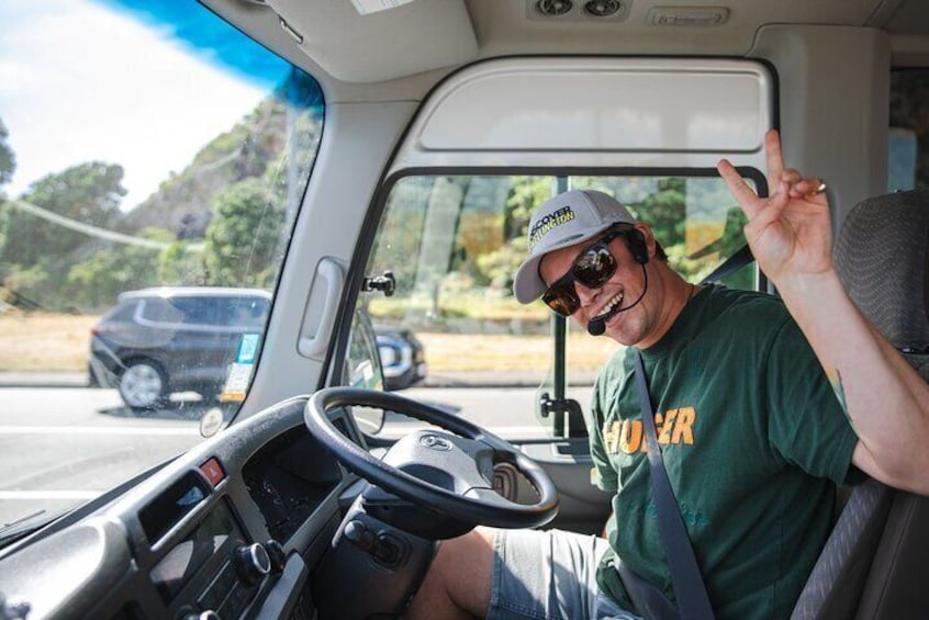 A person driving a truck with a steering wheel and dashboard. 3