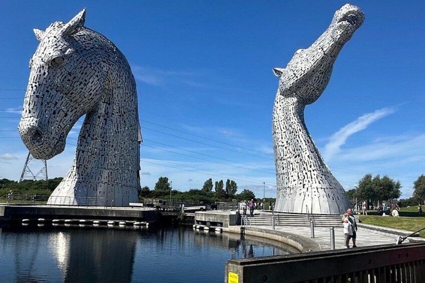 Two large horse sculptures by Kelpies, a bridge, and a body of water. 1