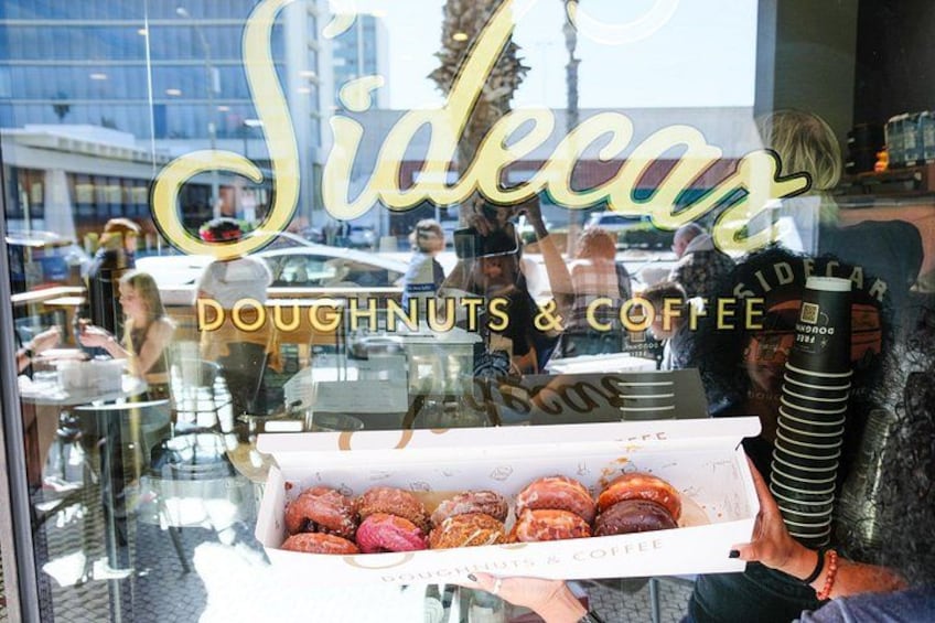 En butik med namnet ”Sidecar” och en skylt som visar ”DONUTS & KAFFE”. 2