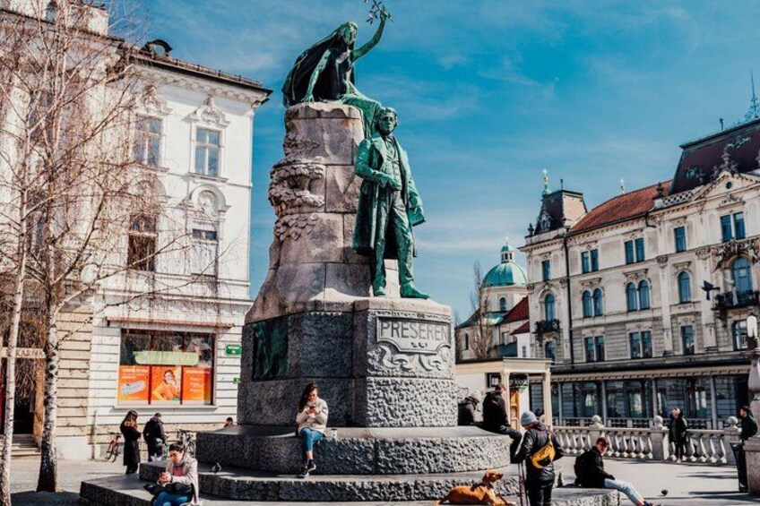 A statue of a historical figure in a public square with buildings in the background. 2