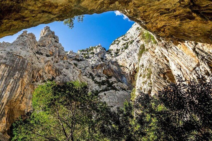 Paisaje montañoso y rocoso con la entrada a una cueva. 1