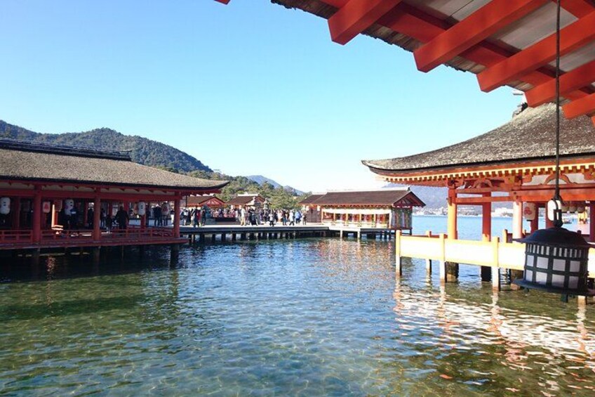 A traditional Japanese structure with a red roof and wooden pillars over a body of water. 2