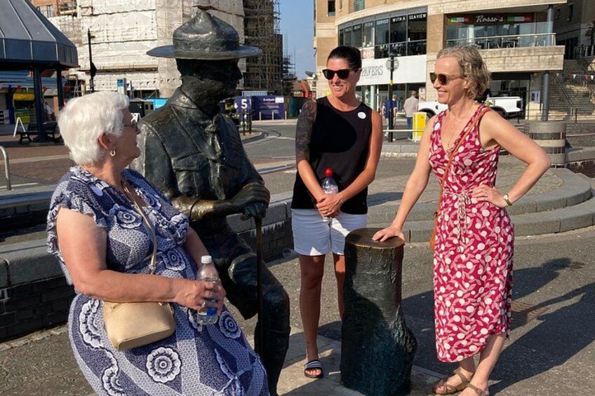 A statue of a soldier, a woman in a red dress, and a man in a black shirt. 1
