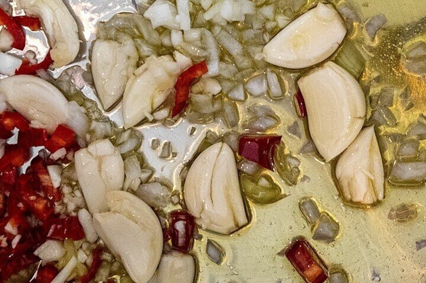 Chopped garlic cloves and red chili peppers in a liquid. 3