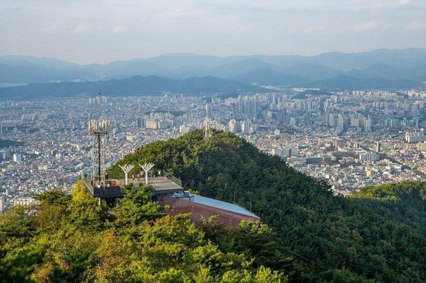 Un paisaje urbano con una edificación en la cima de una colina y una vía. 1