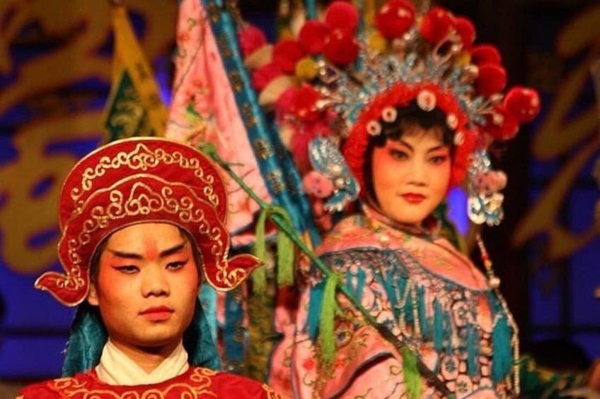 Two individuals in traditional costumes with elaborate headdresses. 2