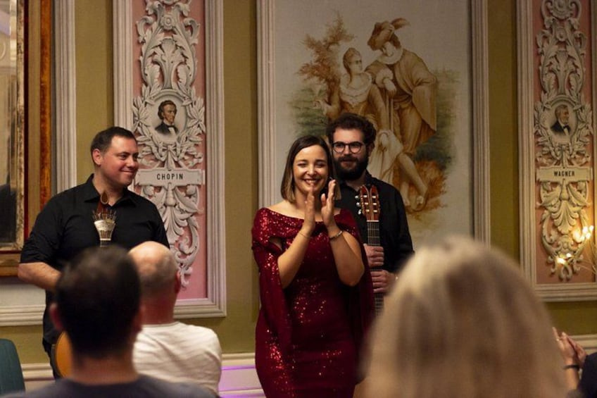 Een formeel evenement met mensen die applaudisseren, een man met een trofee en een vrouw in een rode jurk. 2