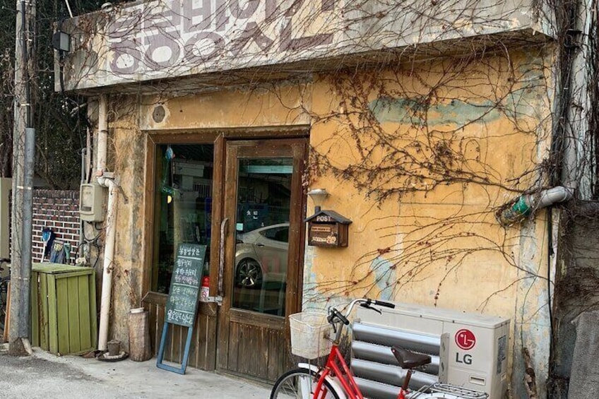 A building with a yellow facade, a wooden door, and a red bicycle parked in front. 5