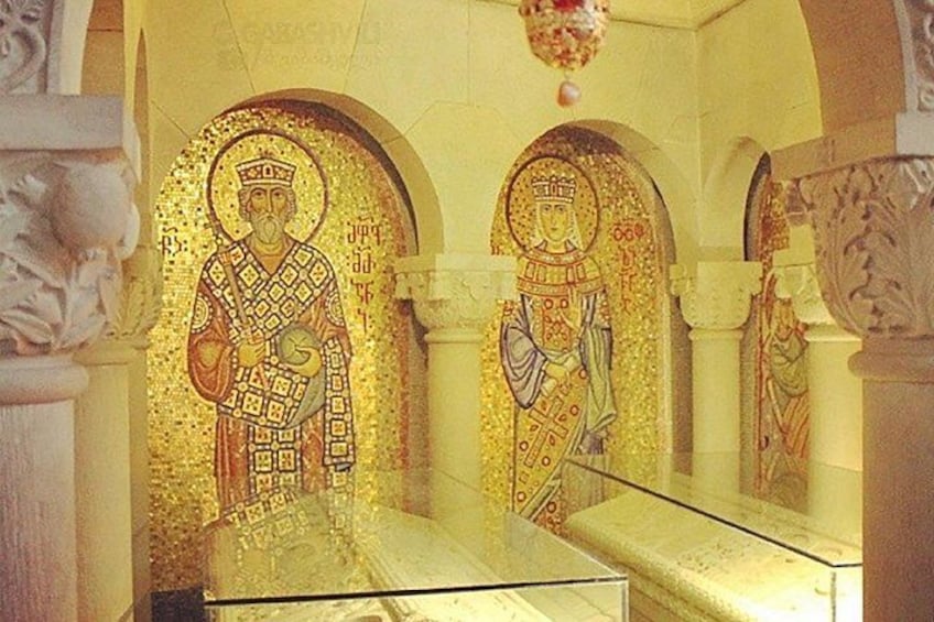 A mosaic of a figure in a robe, a column, and a decorative arch. 4