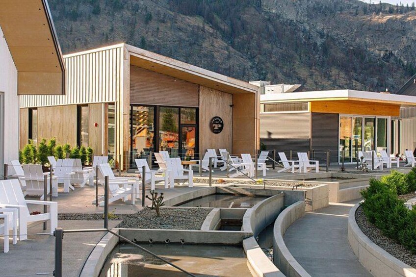 A poolside area with lounge chairs, a building with a modern design, and a mountainous backdrop. 2