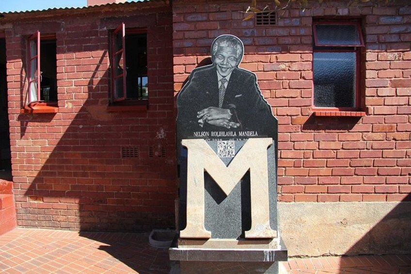 Una placa conmemorativa con una letra 'M' grande y el nombre Nelson Mandela. 3