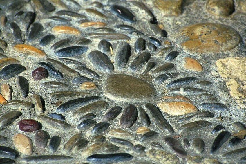 A close-up of a mosaic with variously shaped and colored stones. 3
