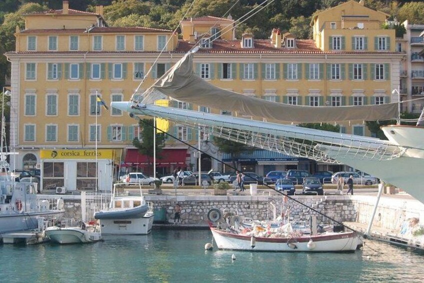 Un puerto deportivo con barcos, un paseo techado y edificios al fondo. 3