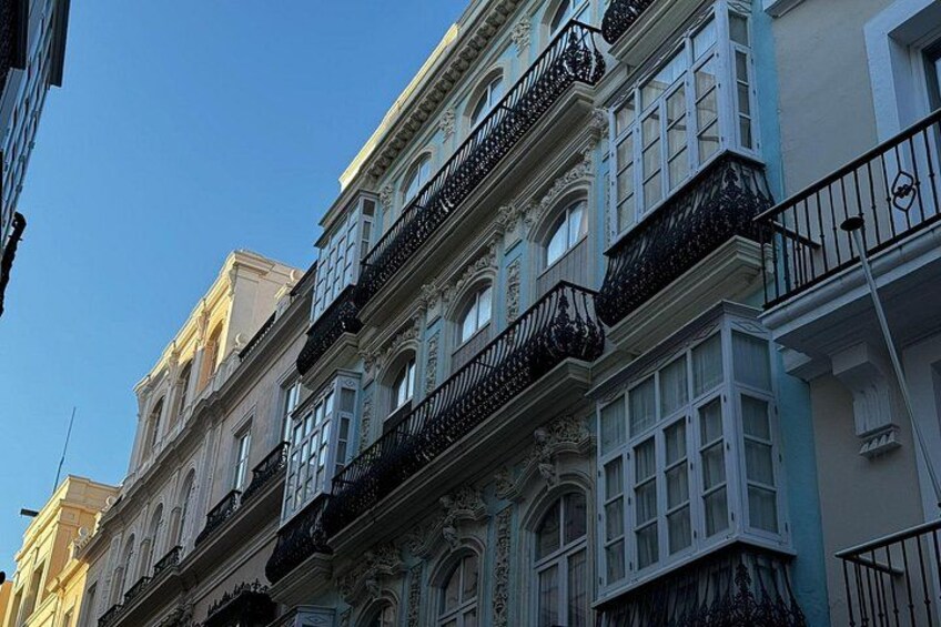 A multi-story building with ornate balconies and windows. 5