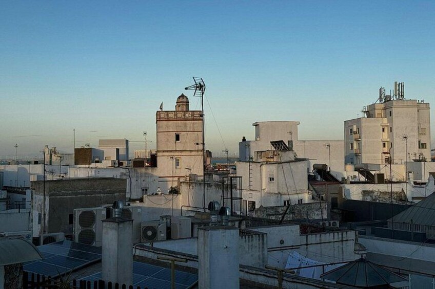 A cityscape with multiple buildings, including a prominent tower with a dome and a flat-roofed structure with antennas. 2