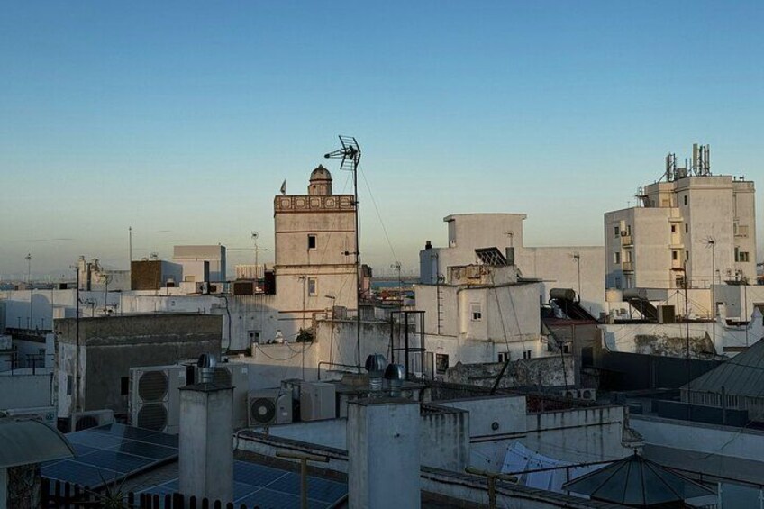 A cityscape with multiple buildings, including a tower with a dome and a rectangular building with antennas. 2