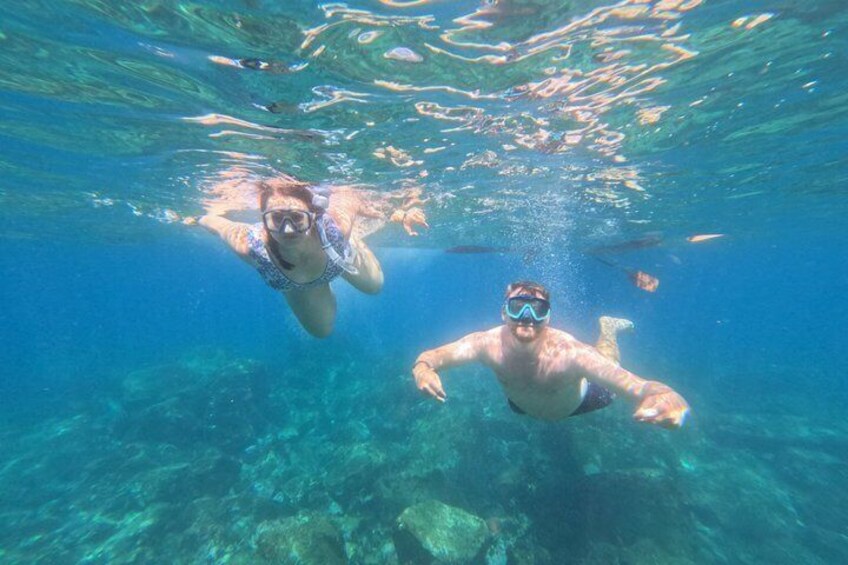 Two people snorkeling underwater with clear water and visible marine life. 5