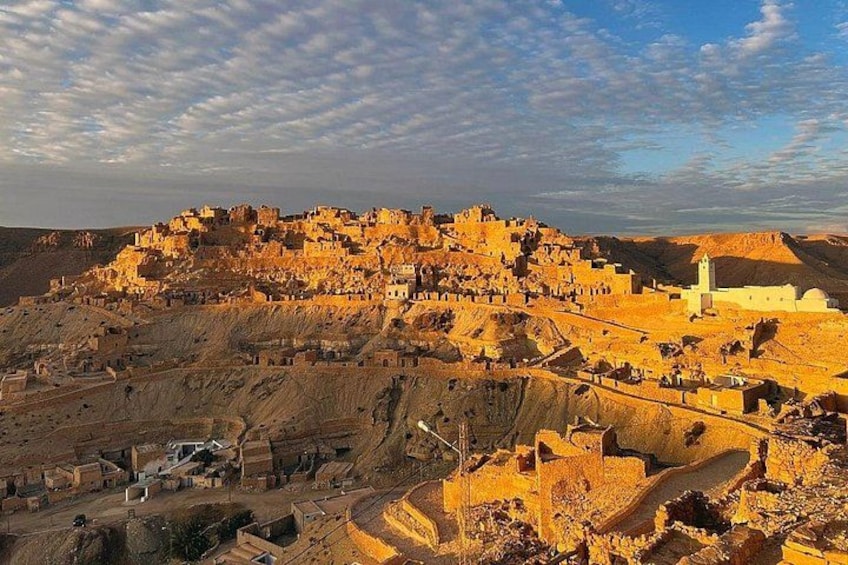 A desert landscape with ancient ruins and a prominent white building. 3