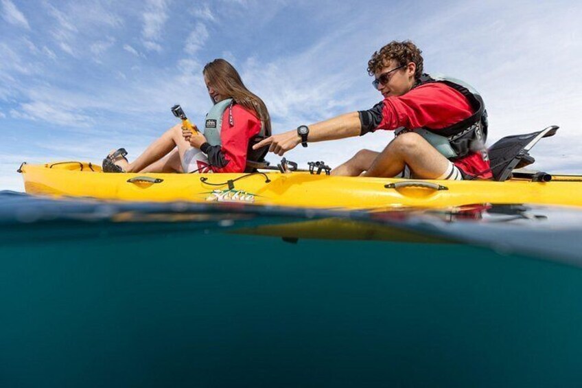 Two people kayaking on a yellow kayak in clear blue water. 5