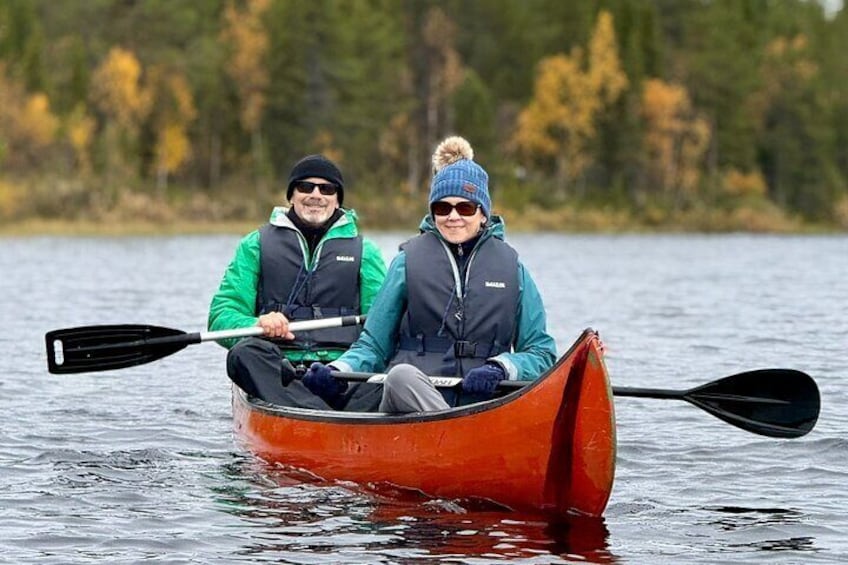 Dos personas en una canoa en un lago rodeado de árboles. 1