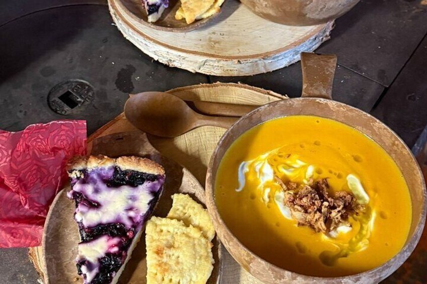 Un tazón de madera con sopa, un trozo de pan y una porción de tarta azul. 5