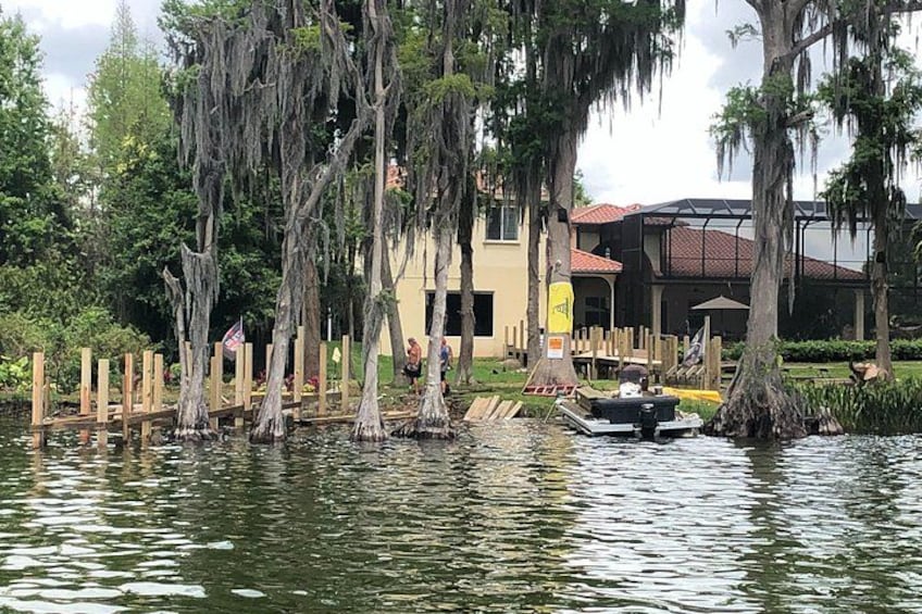 A water body with wooden docks, a boat, and a building with a red roof in the background. 2