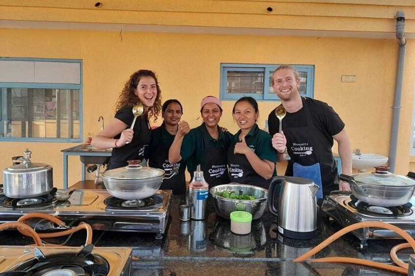 A group of people in a kitchen with cooking utensils and pots. 1