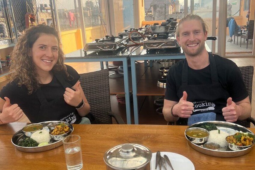 Two people sitting at a table with food and drinks. 3