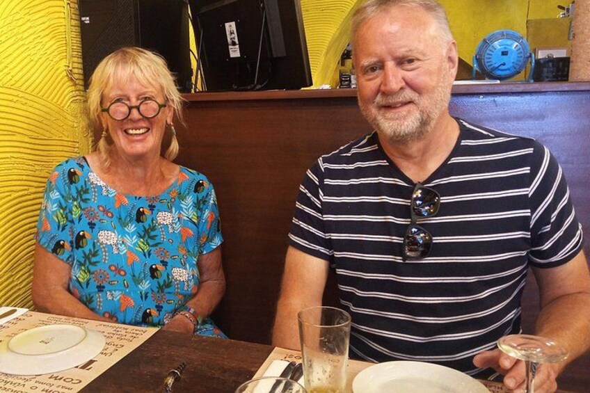 Deux personnes sont assises à une table, devant un menu, un verre d’eau et une assiette. 2