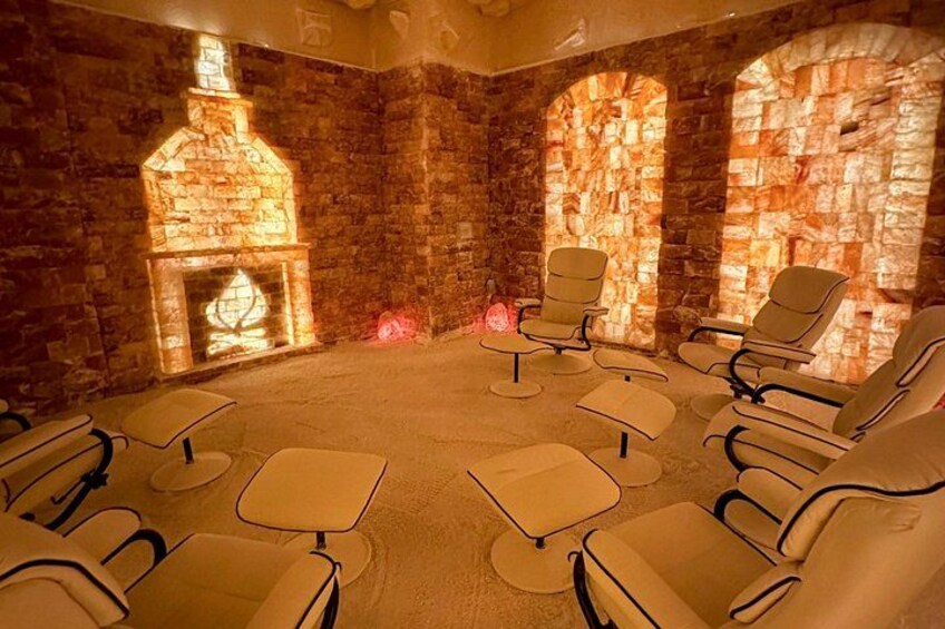 Una habitación con paredes de piedra, una chimenea y varias sillas reclinables. 2